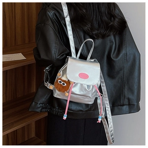 Silver metallic mini backpack detail with pink drawstrings and brown plush charm accessory