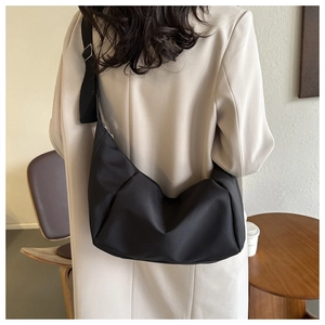 Sac hobo noir en forme de croissant avec large bandoulière en nylon et boucle métal