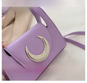 Close-up of purple PU leather bag with a large silver crescent moon buckle detail