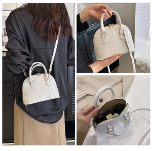 Detail view of white croc-embossed shell bag showing texture and interior storage