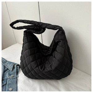 Close-up of black quilted puffer tote bag made of soft nylon fabric with square texture