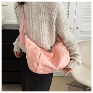 Détail du sac bandoulière demi-lune en nylon rose avec large sangle réglable