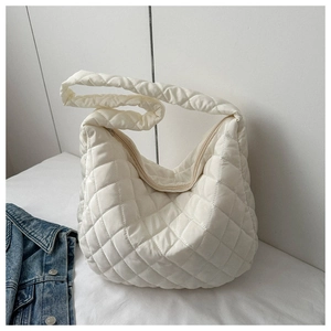 Detail of white quilted nylon tote bag with rhombus pattern and soft puffy texture