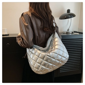 Vue détaillée d'un grand sac hobo argenté matelassé avec une finition métallique