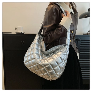 Détail du sac matelassé argenté montrant la texture métallisée et les surpiqûres