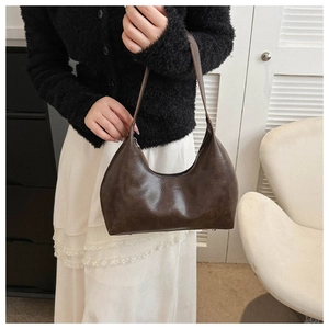 Detail view of a retro dark brown hobo shoulder bag with textured leather and zipper