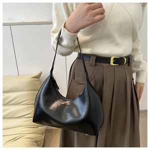 Detail of minimalist black crescent underarm bag with embossed FASHION & BAGS text