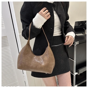 Close-up of vintage brown leather hobo bag with Fashion & Bags logo on tweed coat