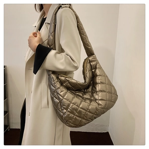Détail du sac matelassé bronze métallisé montrant la texture brillante et la bandoulière