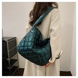 Détail du sac hobo matelassé vert foncé avec fini métallisé et large bandoulière
