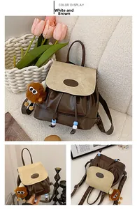 Detail of cream and coffee PU leather mini backpack with drawstring and plush charm