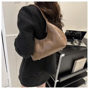 Retro brown half-moon hobo bag in textured leather shown on model for a modern look