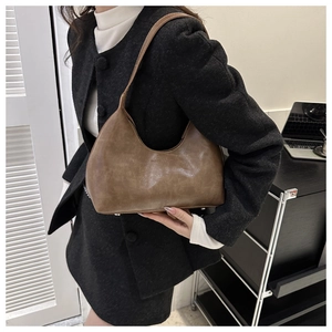 Brown moon bag shown on model with textured finish and silver protective studs