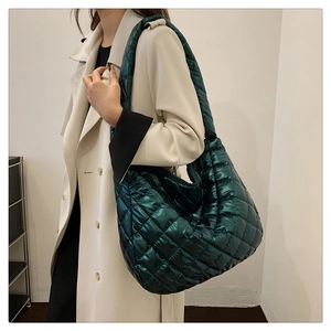 Sac fourre-tout matelassé vert brillant porté avec un trench-coat beige élégant