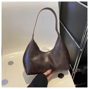 Detail of dark brown oil wax leather shoulder bag with embossed fashion bags text logo