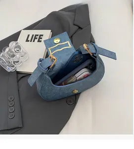 Blue denim crescent bag interior view showing space for phone and lipstick