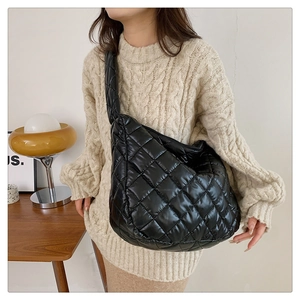Vue détaillée du sac hobo matelassé noir en nylon brillant avec surpiqûres délicates