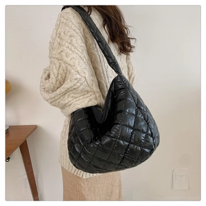 Détail du grand sac hobo matelassé noir au style poudré avec texture souple