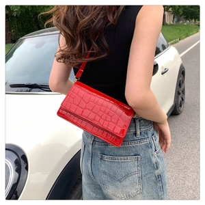 Red crocodile embossed patent leather crossbody bag shown on model for size and fit