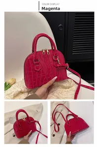 Detail view of the rose red shell bag with crocodile texture and gold hardware accents