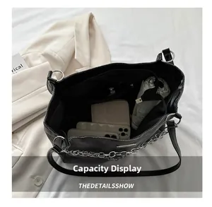 Close-up of the large interior space of the black quilted tote bag with everyday items