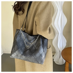 Detail of vintage grey plaid tote bag with metallic chain and heart charm detail