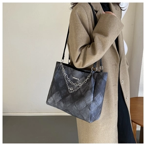 Detail of vintage denim grey tote bag with silver chains and heart pendant on coat