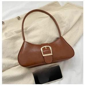 Close-up of vintage brown PU leather shoulder bag with fine texture and gold buckle