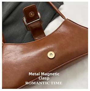 Detail of vintage brown leather handbag featuring a high-quality gold magnetic snap closure