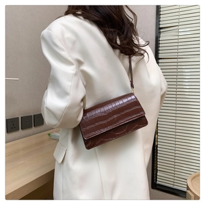 Brown crocodile pattern rectangular crossbody bag shown on a white blazer model
