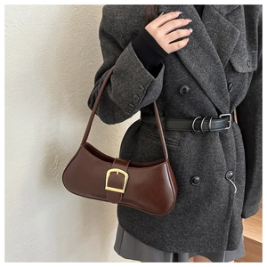 Close-up of brown leather baguette bag with gold buckle on gray herringbone blazer