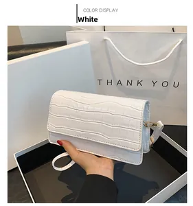 Close-up of white crocodile pattern small square bag with elegant gold metal hardware