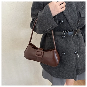 Detail of dark brown leather underarm bag with square buckle and vintage belt decoration