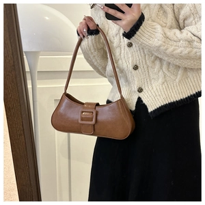 Caramel brown vintage baguette bag with large square buckle shown on woman's shoulder