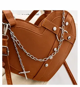 Detail of brown heart-shaped bag with quilted PU leather, metal chains, and silver studs