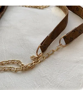 Detail of the golden metal chain and brown vintage floral print shoulder strap
