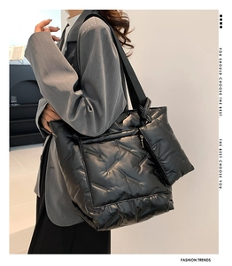 Detail of black quilted puffer tote bag with puffy down texture and front pocket view