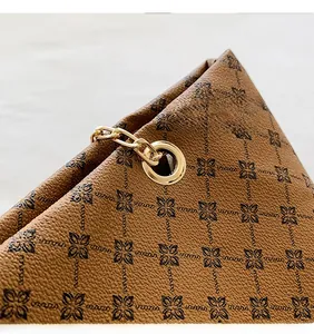 Detailed close-up of vintage brown floral print leather with luxury gold chain hardware