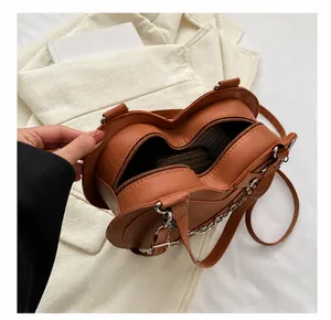 Interior view of brown heart-shaped bag showing main compartment and metal chain strap