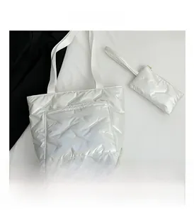 Close-up of a white quilted bucket bag set with matching zipper coin pouch detail