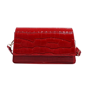 Glossy red crocodile pattern shoulder bag with golden hardware on white background