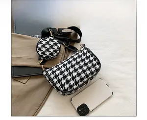 Detail of black and white houndstooth crossbody bag set with wide strap and round pouch