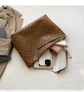 Spacious interior of brown tote bag showing capacity for tablet, wallet, and notebooks