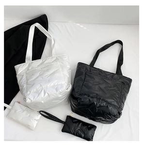 Detail view of glossy quilted tote bag sets in black and white with mini coin purses
