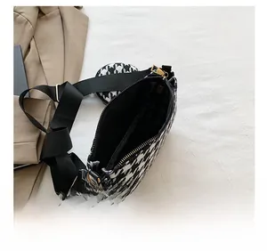 Detail view of houndstooth crossbody bag interior and multi-pocket storage design