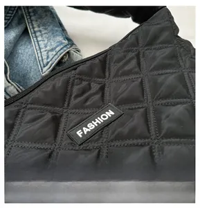Gros plan sur le sac bandoulière en nylon noir matelassé avec détail d'étiquette mode