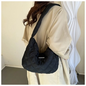 Détail du grand sac cabas noir matelassé à losanges avec étiquette mode chic
