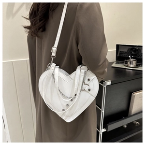 Detailed back view of a white heart-shaped crossbody bag with silver chains and studs