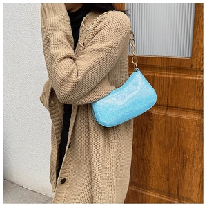Dettaglio della borsa sottobraccio con paillettes blu chiaro e catena dorata su modella
