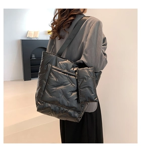 Detail of black quilted down tote bag with matching zipper pouch and nylon strap